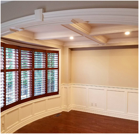 An image of a ceiling with crown moulding and pot lights