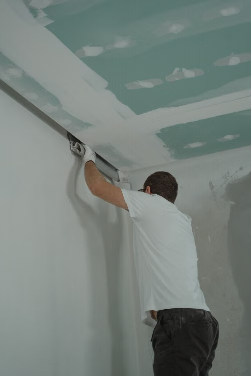 An image of a worker repairing a ceiling