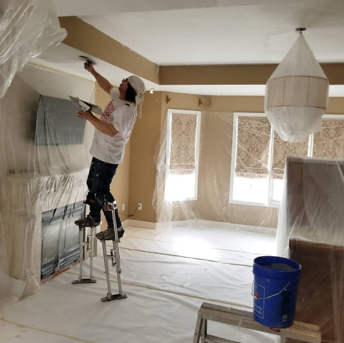 An image of a professional painting a ceiling